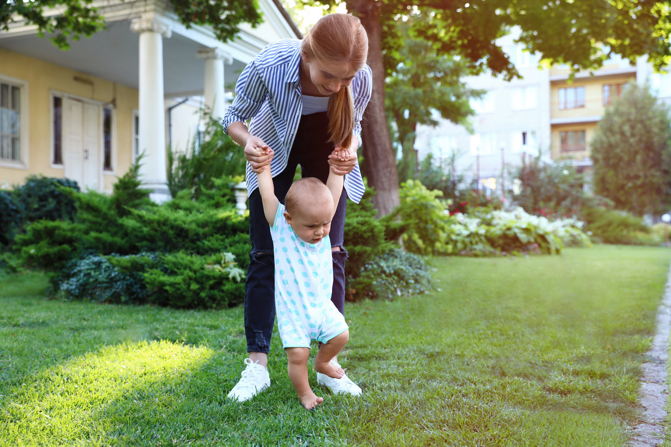 Teen Nanny with Cute Baby on Green Grass Outdoors